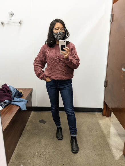 Self care coach Charissa Pomrehn takes a selfie in a thrift shop mirror.
